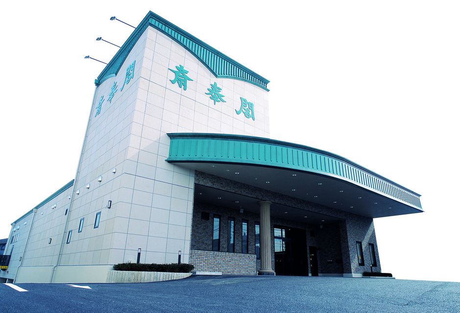 会館全景：最寄りの駅は近鉄阿倉川駅となります。国道１号線の金場の交差点を３００メートルほど西に進んだ所にあり、交通のアクセスも便利です。駐車場は１００台ご用意しており、お車でお越しの際の準備も整えております。